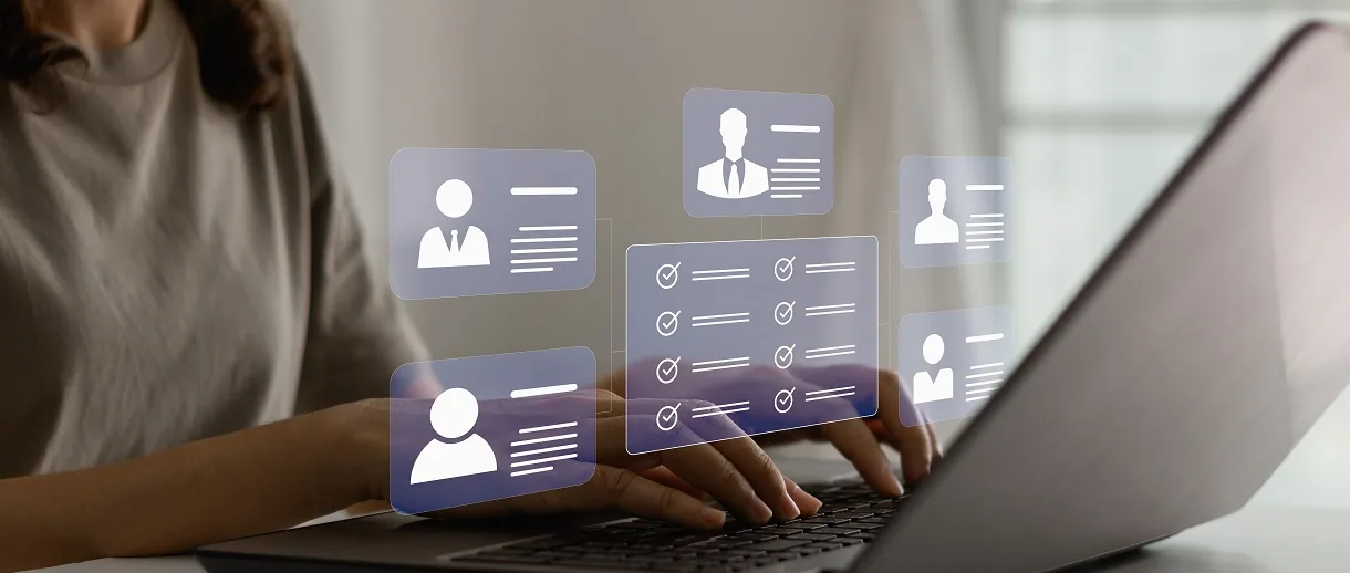 Hands typing on a laptop, surrounded by floating digital profile icons and checklists. Soft lighting, neutral tones convey a tech-focused mood.